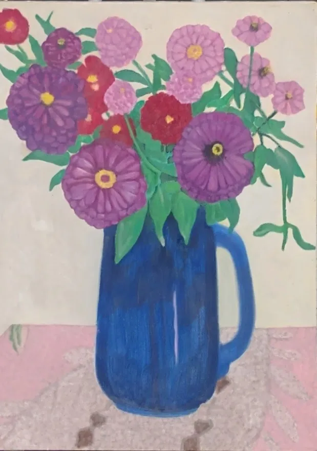 Blue pitcher holding pink, purple, red flowers